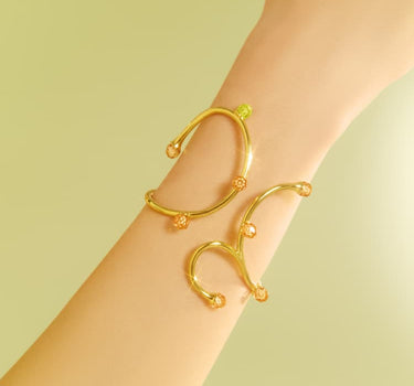Brazalete rígido dorado con cristales de ópalo y topacio